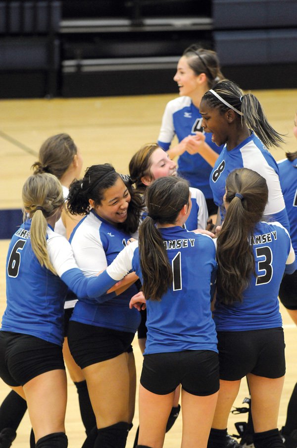 Ramsey’s Tiarra McDonald and her teammates celebrate the winning point for the Lady Rams victory over Trinity in the junior high regional volleyball tournament on Saturday in Rogers Heritage high school in Rogers.
