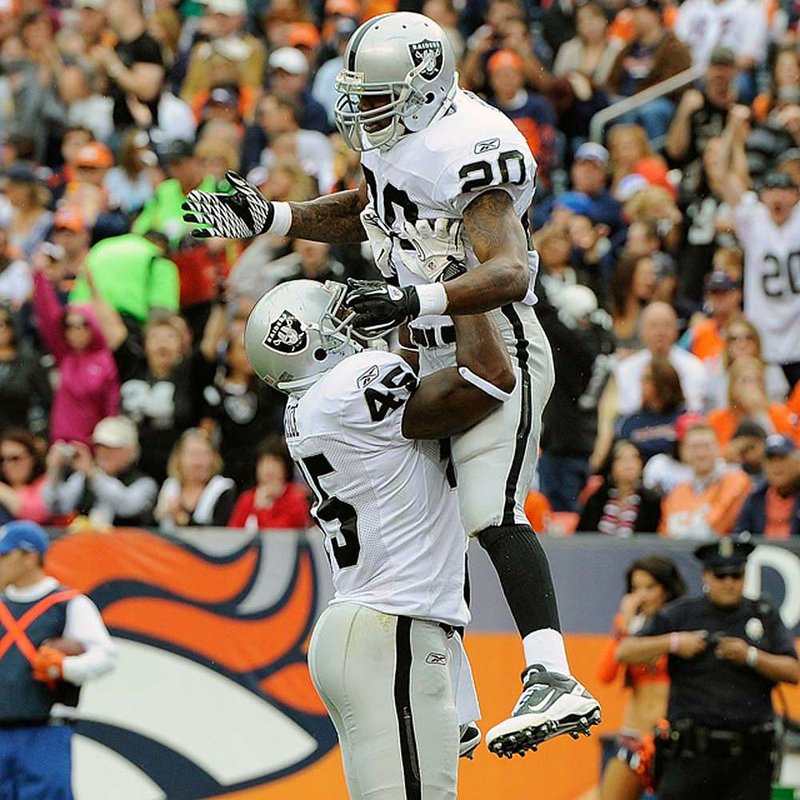 Oakland Raiders running back Darren McFadden celebrates with teammate Marcel Reece after one of McFadden’s three touchdowns in the first half of Sunday’s game against the Denver Broncos.