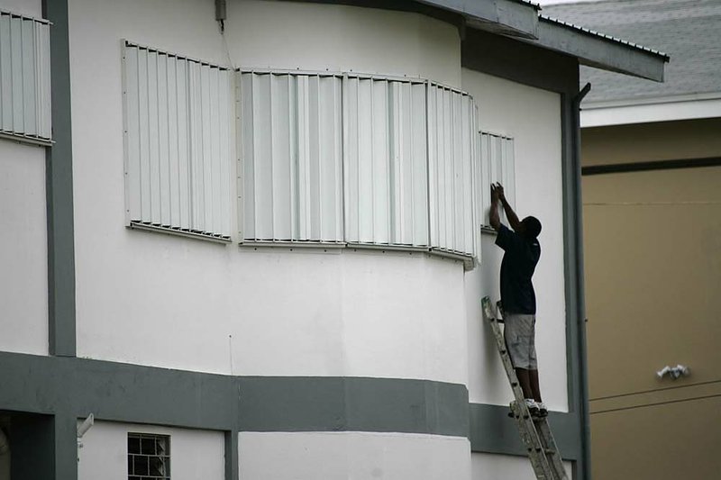 A man places protective shutters over windows Sunday a few hours before the arrival of Hurricane Richard in Corozal, Belize. 