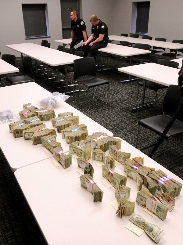 Bentonville Police Officers Keith Lindley, left, and David Undiano took part in a marijuana bust Monday morning that netted more than $134,000 in cash and approximately one-half pound of marijuana. Three suspects were arrested in connection with the raid.