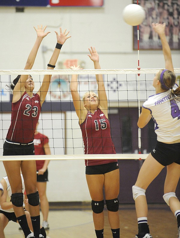 Siloam Springs junior Lindsey Larkin, center, and senior Lizzy Briones defend against a kill by Fayetteville sophomore Aubrey Edie during the second game on Aug. 26 at Fayetteville.