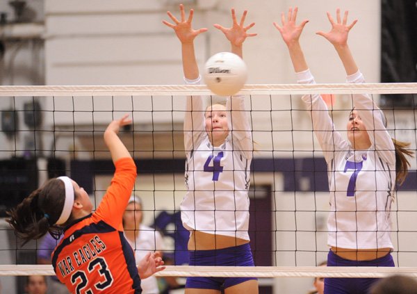 Fayetteville sophomore Aubrey Edie, center, blocks a kill by Rogers Heritage sophomore Emily Alderson as Fayetteville junior Shannon Airola reaches to defend during the first game on Sept. 28 at Fayetteville.