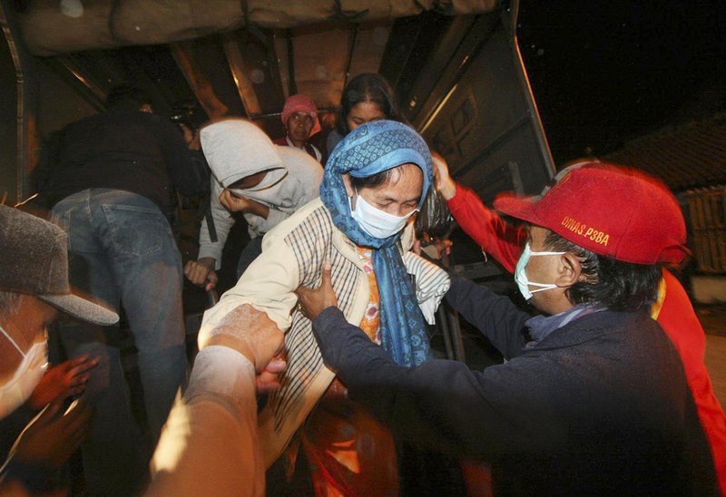 Rescue workers help villagers upon arrival at a temporary shelter after they were evacuated from their homes on the slope of Mount Merapi following its eruption in Pakem, Yogyakarta, Indonesia, Tuesday, Oct. 26, 2010. Indonesia's most volatile volcano started erupting Tuesday, after scientists warned that pressure building beneath its dome could trigger the most powerful eruption in years. 