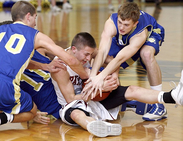 Siloam Springs’ Kyle Teague battles to keep the ball as Harrison players try to strip it from him during the first half Jan. 16 in Siloam Springs.