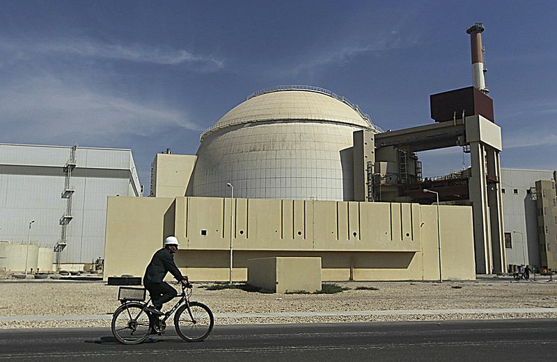 A worker bicycles in front of the reactor building of the Bushehr nuclear power plant Tuesday just outside the southern port city of Bushehr, Iran.