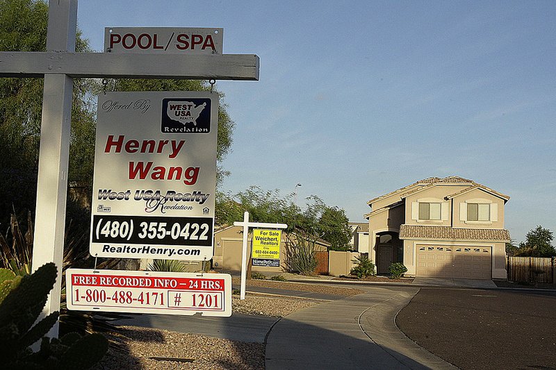 Realty signs hang in front of homes for sale Monday in a housing development in Phoenix, the city that experienced the biggest drop in homes prices in August compared with July in the Standard & Poor’s/Case-Shiller 20-city home price index released Tuesday. 