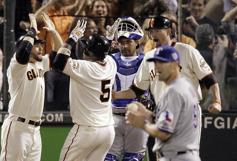 Texas pitcher Darren O’Day looks away as San Francisco’s Juan Uribe celebrates a three-run fifth-inning home run with Cody Ross and Aubrey Huff.