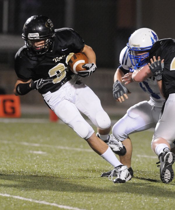 Bentonville Black’s Clay Wallace cuts upfield against Rogers High on Oct. 14 in Tiger Stadium in Bentonville.