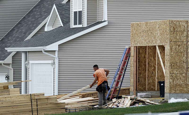 A construction worker moves boards last month at a new home site in West Des Moines, Iowa in this September 2010 file photo.