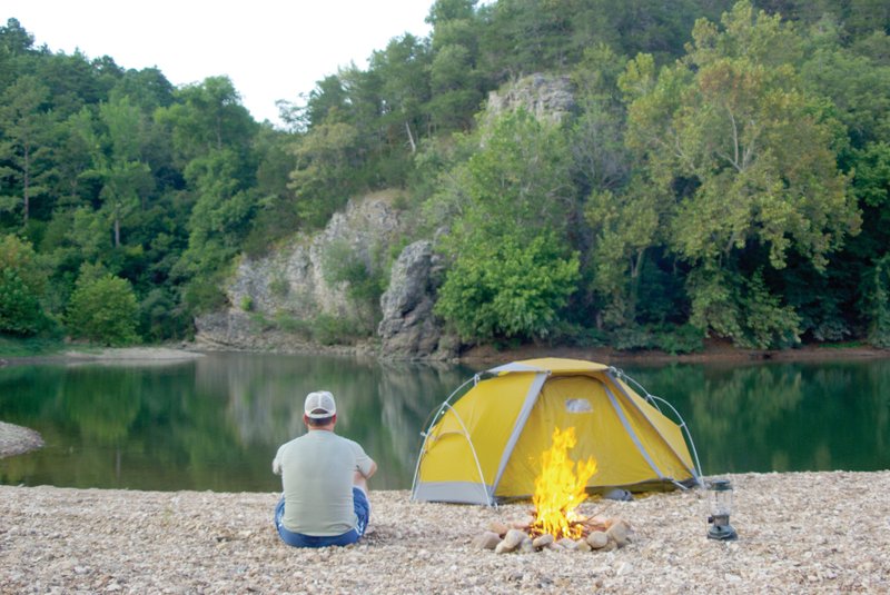 Glenn Wheeler of Harrison relaxes and enjoys the view at a campsite on the Buffalo River near Woolum.