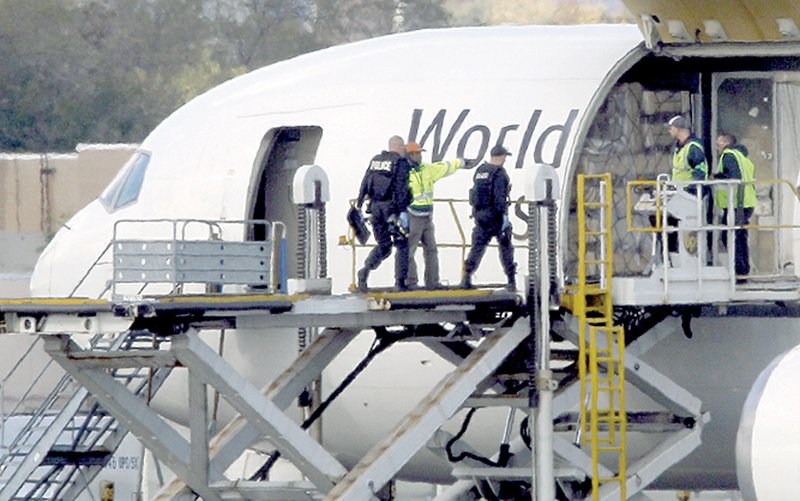 Investigators board a United Parcel Service jet isolated on a runway at Philadelphia International Airport in Philadelphia, Friday, Oct. 29, 2010. Law enforcement officials are investigating reports of suspicious packages on cargo planes in Philadelphia and Newark, N.J. 