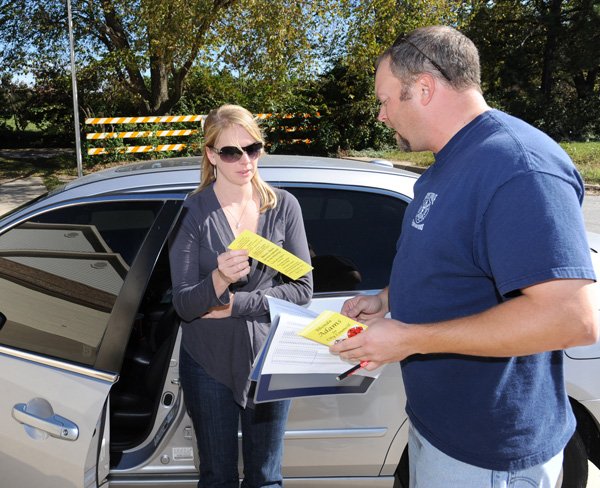 SHOWING SUPPORT - Jeremy Ashley, a firefighter with the Fayetteville Fire Department, right, hands literature in support of Rhonda Adams, a candidate for City Council on Friday to Ward 4 resident Stephanie Burch along El Paso Drive in Fayetteville. Members of the Fayetteville chapter of the International Association of Firefighters have spent time campaigning for candidates the association supports in the area.