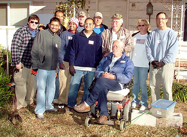 Bart Nelson, Korean War veteran, sits in his wheel chair with the good neighbors who are rebuilding his home. Pictured with Nelson are Chris Mackey, Chet Patel, Shawn Govino, Nick Nagin, Rocky Govino, Jeff Duram, Roger McGovern, Bettie Duram and Byrom Bean.