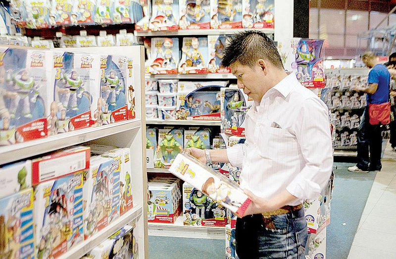 A shopper looks at a Toy Story 3 action figure at the Toys R Us Inc. store in New York. The retailer is among those who have made layaway plans available to shoppers this year. 