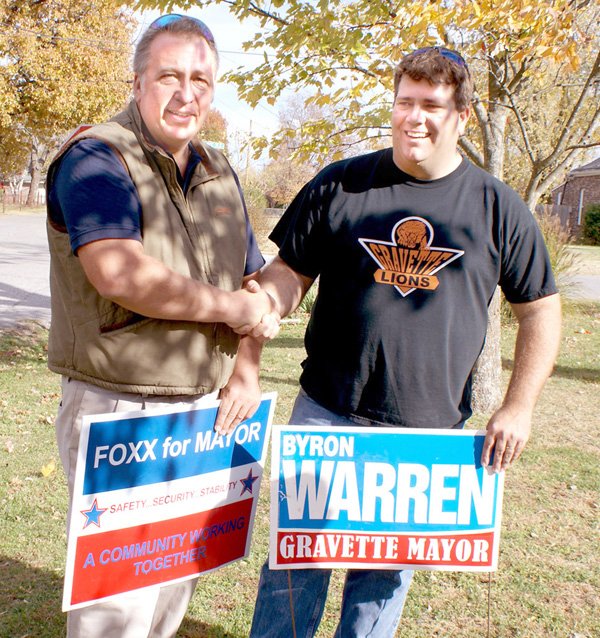 Ken Foxx and Byron Warren, candidates for Mayor of Gravette, shake hands as they worked together removing campaign signs after Foxx withdrew from the race. Both names will be on the ballot in a run-off election which is scheduled for Tuesday; however votes cast for Foxx will not be counted according to the Benton County Election Commission. Mike von Ree, who finished third in the initial balloting, filed suit in Circuit Court asking the election be voided, charging Foxx does not qualify for the office because of a question of his residence. Judge Xollie Clinger has been assigned the case and a ruling has not been made at press time.

