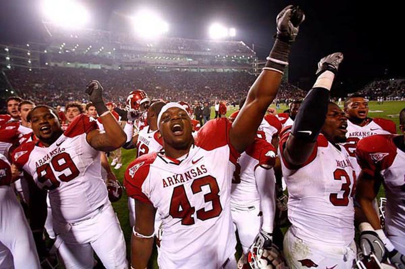 Arkansas defensive end Tenarius Wright (43), who hit Mississippi State quarterback Chris Relf on fourth down in the second overtime and forced an incomplete pass, celebrates Arkansas’ 38-31 victory with defensive lineman Lavunce Askew (99) and linebacker Jerry Franklin (34). 