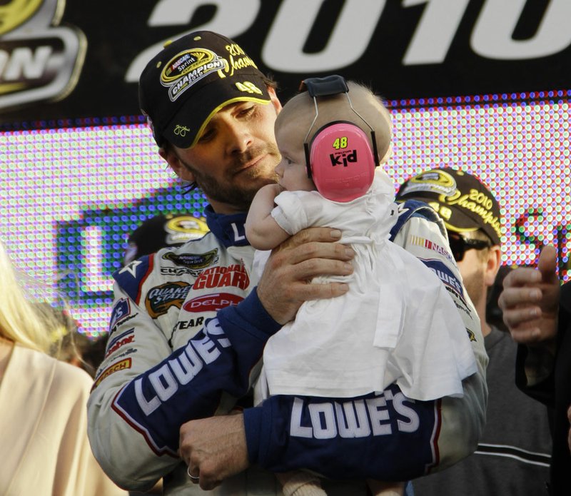 NASCAR driver Jimmie Johnson holds his daugher, Geneviene, after winning his fifth Sprint Cup Series Championship Sunday, Nov. 21, 2010 in Homestead, Fla.