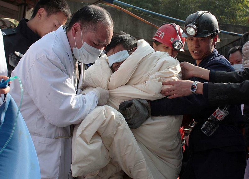Rescuers carries a trapped miner wrapped in white quilts out from the flooded Batian Coal Mine in Xiaohe town of Weiyuan county in southwest China's Sichuan province Monday, Nov. 22, 2010.