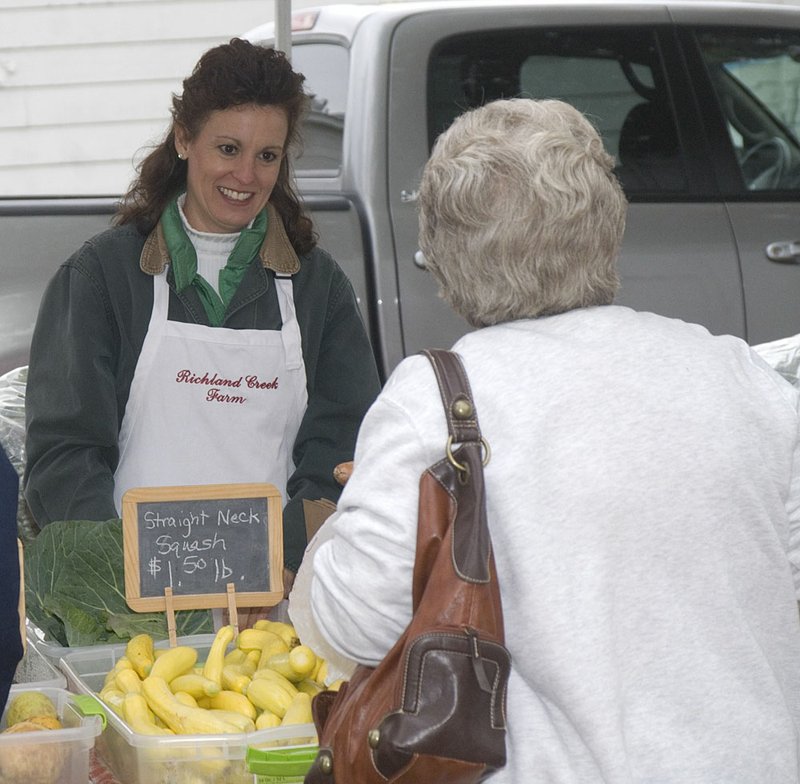 Rhonda Rudder sells her homegrown fruits and vegetables at the corner of Fifth Street and College Avenue in El Dorado last week. 