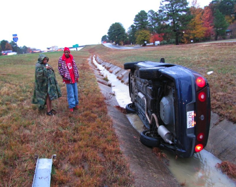 Quentin Tucker stands with his mother outside his car a short time after it veered off the highway and ended up in a drainage ditch. Tucker was the only one in the vehicle.