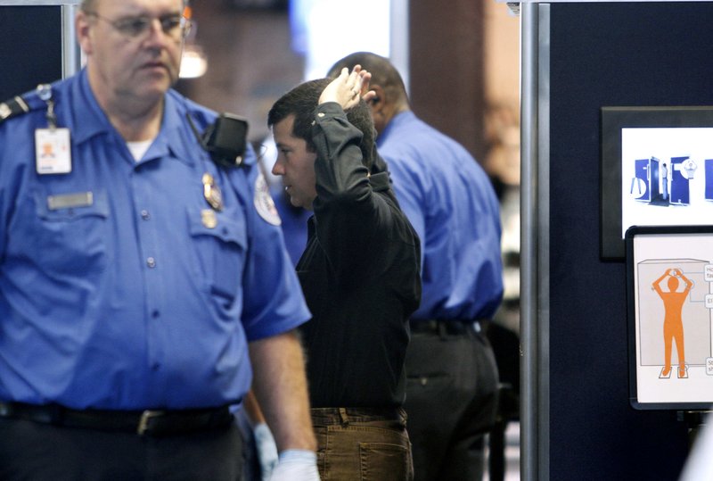 A passenger goes through a full-body scanner at Logan International Airport in Boston, Wednesday, Nov. 24, 2010. 