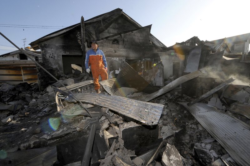 A South Korean resident stands on the rubble of a destroyed house on Yeonpyeong island, South Korea, on Wednesday, Nov. 24, 2010. So