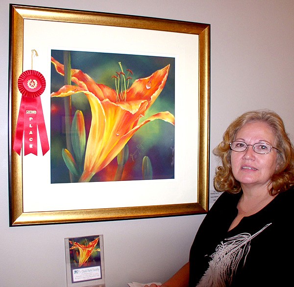 Local artist Susan Edgmon poses with an award-winning painting.