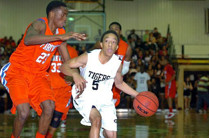  Little Rock Central’s Larry Wilbern drives past Little Rock Parkview’s Adoyi Emanual during Tuesday night’s game. 