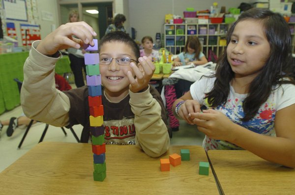 Izaac Haro, left, and Jasmine Gonzalez stack cubes during an exercise in creating shapes at Russell Jones Elementary in Rogers. Northwest Arkansas’ larger school districts have experienced a rapid growth in the number of minority students, especially in Rogers and Springdale, since the mid-1990s.