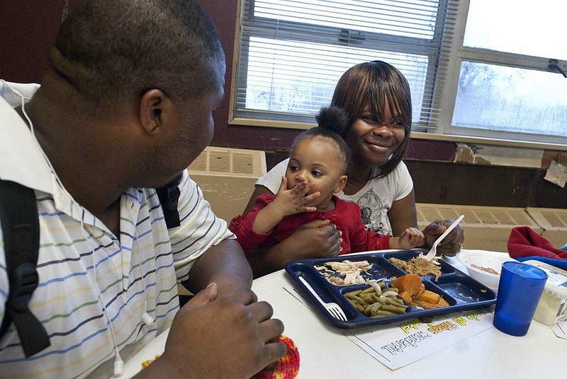 Carma Jones eats Thanksgiving dinner Thursday with her parents, Charles Jones and Eleasha Brown, and other members of her family at the Little Rock Compassion Center. 