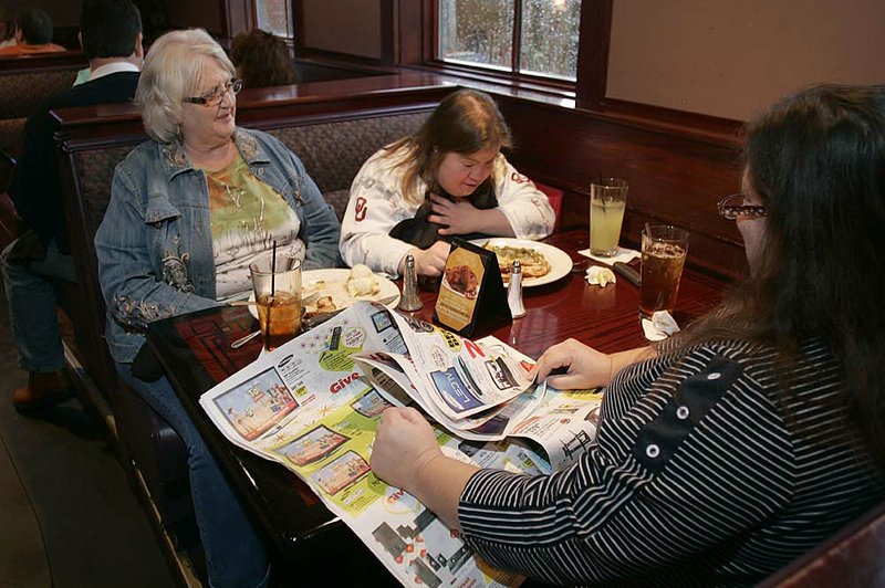 Sue McEvoy (left) of Bella Vista sits with her friends Stacey Parsons and Kelly Pope, both of Bentonville, as they finish their traditional Thanksgiving meal at Copeland’s of New Orleans in Rogers on Thursday afternoon. 