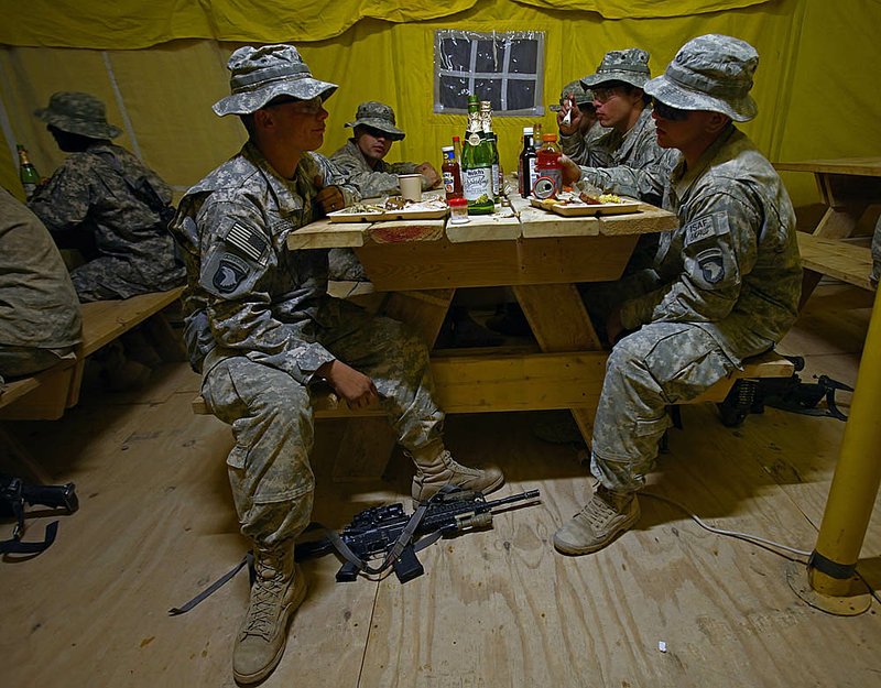 U.S. soldiers chat Thursday while celebrating Thankgiving Day at their base in Afghanistan’s Kandahar province.

