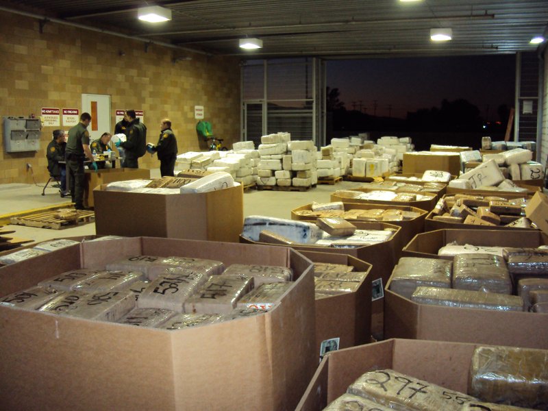 In this Nov. 25, 2010 photo released by U.S. Immigration and Customs Enforcement (ICE), packages of seized marijuana are examined by officials in Murrieta, Calif., after a cross-border tunnel between Tijuana, Mexico and San Diego was discovered. U.S. authorities said Friday that they seized tons of marijuana in connection with a tunnel that was equipped with a rail car _ the second discovery of a major underground drug passage in San Diego this month. U.S. authorities followed a trailer from one of the warehouses to a Border Patrol checkpoint in Temecula, where they seized 27,600 pounds of marijuana, Mike Unzueta, head of investigations at U.S. Immigration and Customs Enforcement in San Diego, said. 