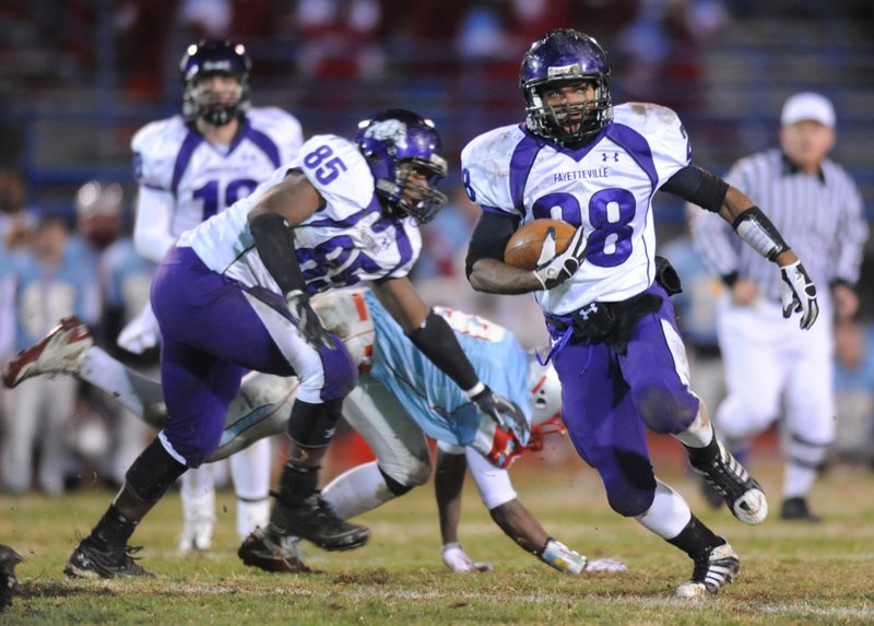 Fayetteville senior Devin Bowers (85) frees sophomore running back Brice Gahagans, right, during the first half of play Friday, Nov. 26, 2010, at Jim Rowland Stadium in Fort Smith.