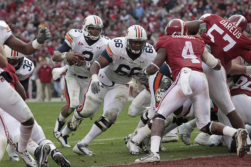 Auburn quarterback Cam Newton (2) follows a block by offensive lineman Mike Berry (66) for a 1-yard touchdown run during the third quarter of the No. 2 Tigers’ 28-27 victory over the No. 11 Crimson Tide on Friday in Tuscaloosa, Ala. 