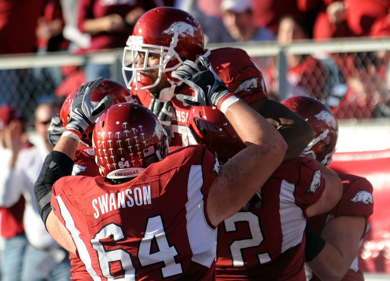 Knile Davis (top center) celebrates the Razorbacks' first touchdown against LSU during the game Saturday at War Memorial Stadium in Little Rock.