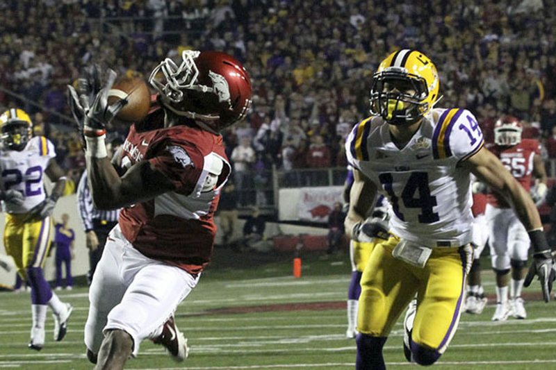 Arkansas receiver Joe Adams catches a fourth-down pass from Ryan Mallett in front of LSU defender Tyrann Mathieu, part of a 39-yard scoring play, giving the No. 12 Razorbacks a 28-21 lead in a 31-23 victory over No. 5 LSU on Saturday at War Memorial Stadium in Little Rock. 