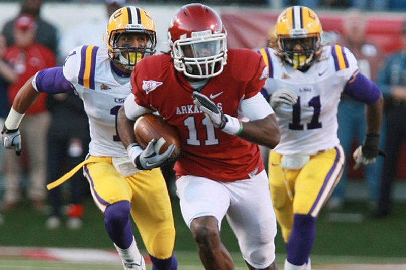 Arkansas receiver Cobi Hamilton (11) is chased by LSU defensive back Eric Reid (left) and linebacker Kelvin Sheppard on an 80-yard touchdown pass in the second quarter of Saturday’s game at War Memorial Stadium in Little Rock. The touchdown gave Arkansas a 21-14 halftime lead.

