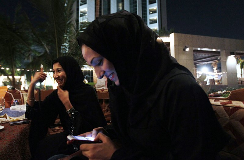 Saudi women with cell phones smoke tobacco from a waterpipe earlier this month as they drink coffee in Jeddah, Saudi Arabia. 