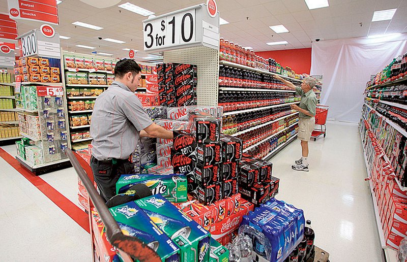 A Coca-Cola employee stocks soft drinks at a Target store in Altamonte Springs., Fla., in June. The company said it is on track to improve water efficiency at its 1,000 bottling plants.

 
