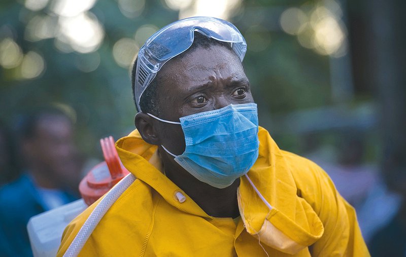 A worker in Port-au-Prince takes precautions against the cholera outbreak that has swept the Haitian capital.

