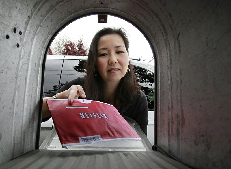 Carleen Ho pulls a Netflix movie from her mailbox in Palo Alto, Calif., earlier this year.