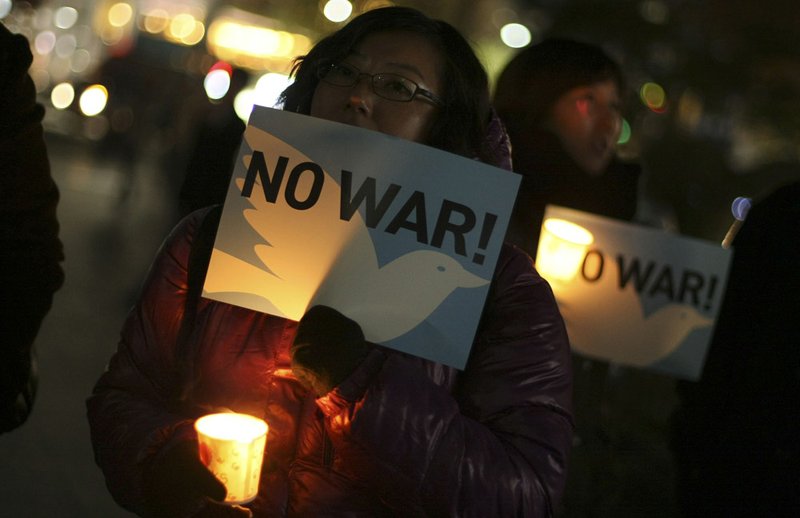 Pro-reunification activists denounce the war games between South Korea and the United States during a candlelight vigil, Monday, Nov. 29, 2010, in Seoul, South Korea.
