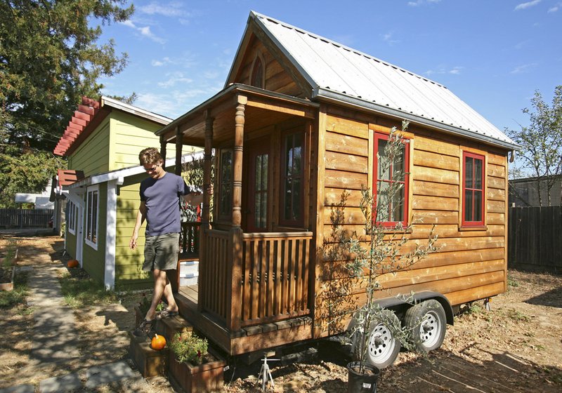 In this photo taken Oct. 14, 2010, Jay Schafer, owner of Tumbleweed Tiny Houses, exits a tiny house he built for himself in Graton, Calif. In a country where most people want to live large, Schafer helps people live small.