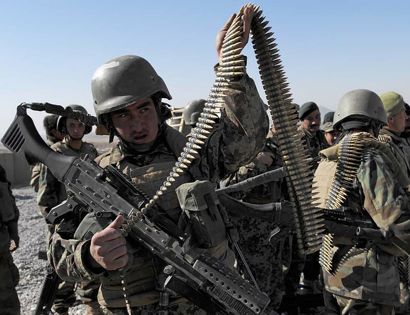 Afghanistan soldiers attached to the 101st Airborne Division take off their ammunition before a training-program graduation Monday in Afghanistan’s Panjwai district. 