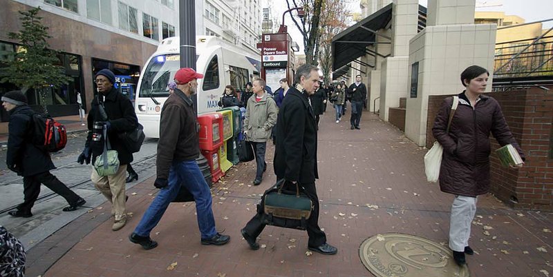 Commuters walk near Pioneer Courthouse Square on Monday in Portland, Ore. 