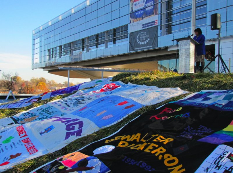 FILE - Volunteer Kimara Randolph reads the names of people who died from AIDS at a display of the AIDS Memorial Quilt Wednesday outside the Clinton Center on Dec. 1, 2010.