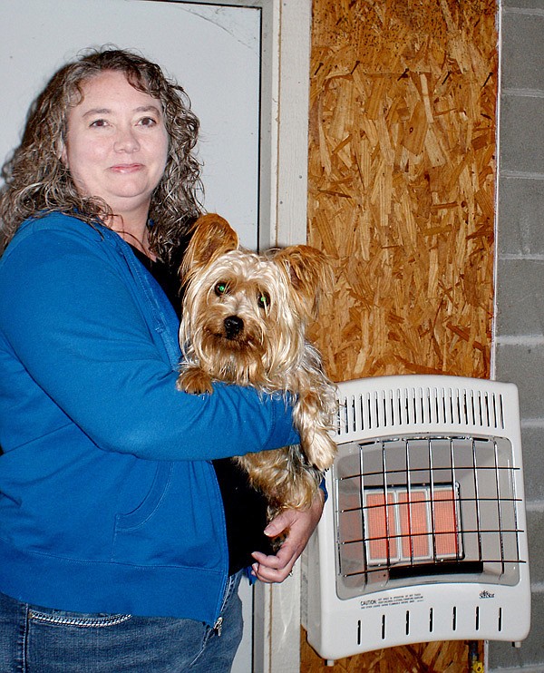 Berry is shown with a Yorkie that was recently picked up in town and has been returned to its owner. The new heating unit is in the background of the photo.