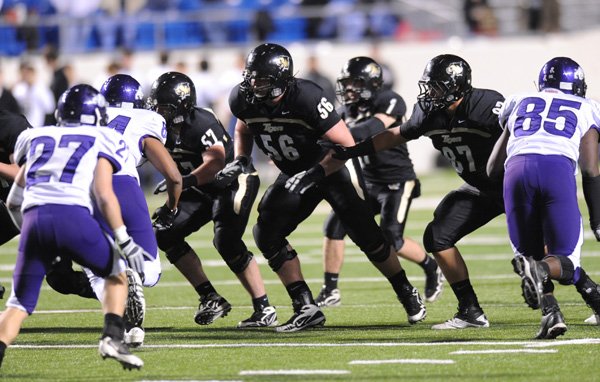 Bentonville offensive lineman Marcus Danenhauer, center, prepares to block against the Fayetteville defensive line in the first half of the Class 7A State Championship Game on Dec. 3 in War Memorial Stadium in Little Rock.