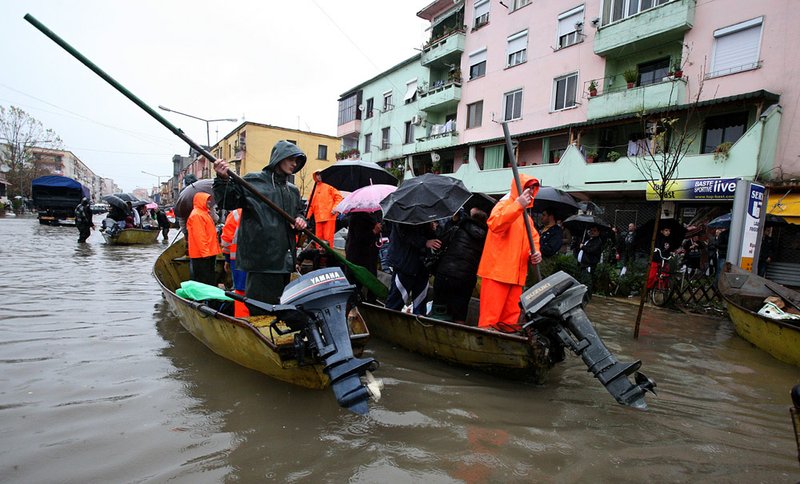People in boats and on foot move through the floodwater in Shkodra 75 miles northwest of the Albanian capital, Tirana,Saturday, Dec. 4, 2010 . Thousands of people and livestock are being evacuated from increased flooding in northwestern Albania. Authorities say water levels of the Drini River cascade are reaching maximal points following days of torrential rain obliging them to pour out much of that, thus flooding more than 10,000 hectares of land.